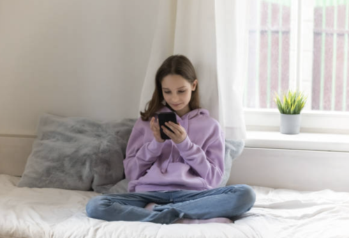 kid on a phone by herself - kids winter depression